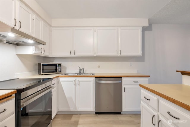 kitchen featuring sink, a textured ceiling, light wood-type flooring, stainless steel appliances, and white cabinets