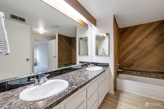 bathroom featuring a tub to relax in, wood-type flooring, and vanity