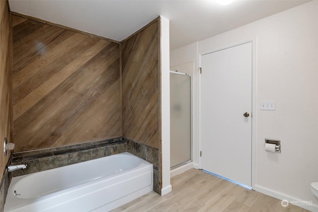 bathroom with plus walk in shower, hardwood / wood-style floors, and toilet