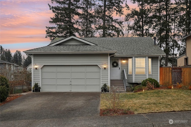 ranch-style house featuring a garage and a lawn