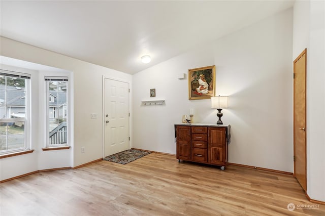 entryway with light hardwood / wood-style flooring and vaulted ceiling