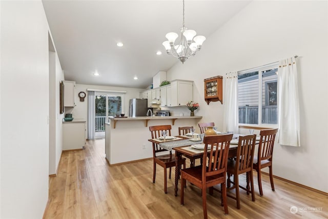 dining area featuring high vaulted ceiling, light hardwood / wood-style floors, and a notable chandelier