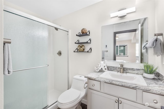 bathroom featuring walk in shower, vanity, and toilet