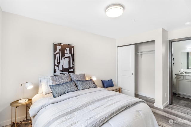 bedroom featuring connected bathroom, hardwood / wood-style flooring, and a closet