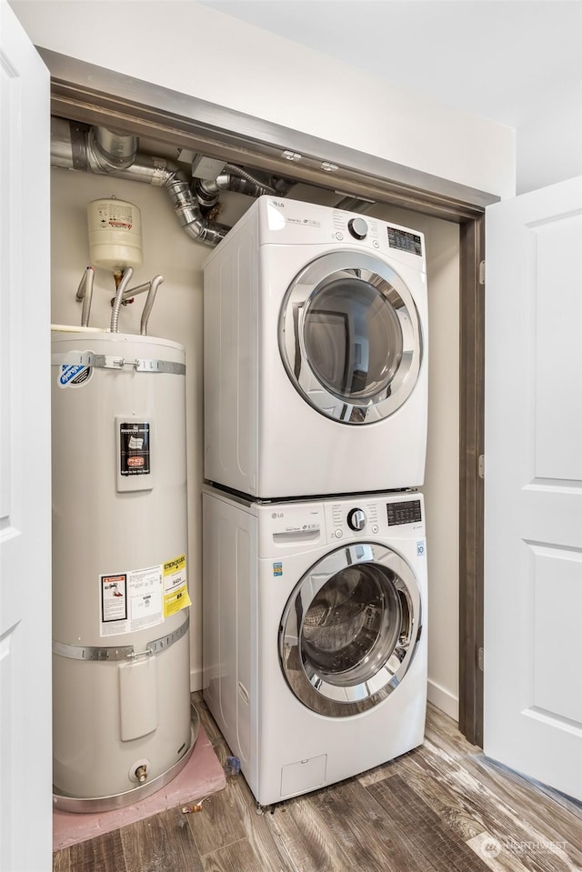 washroom featuring stacked washer / drying machine, hardwood / wood-style floors, and water heater