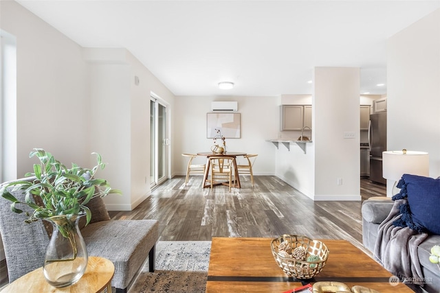 living room with dark wood-type flooring, sink, and a wall unit AC