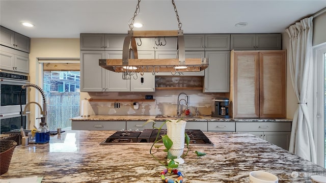 kitchen featuring light stone counters, sink, and stainless steel appliances