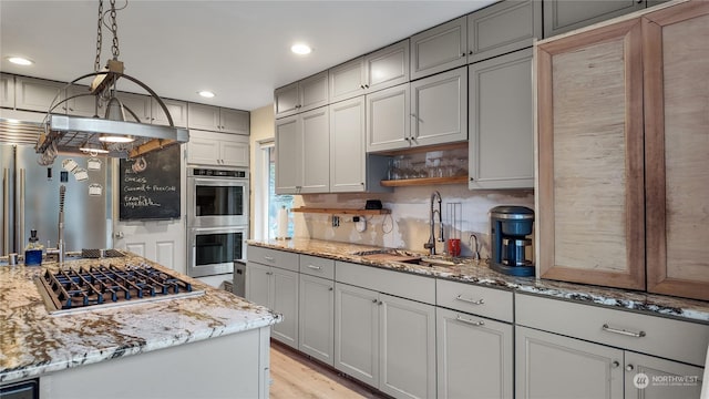 kitchen featuring stainless steel appliances, light stone countertops, gray cabinetry, and pendant lighting