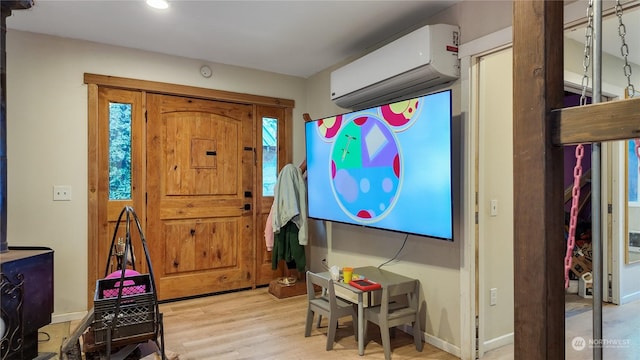 entryway with a wall mounted air conditioner and light hardwood / wood-style flooring