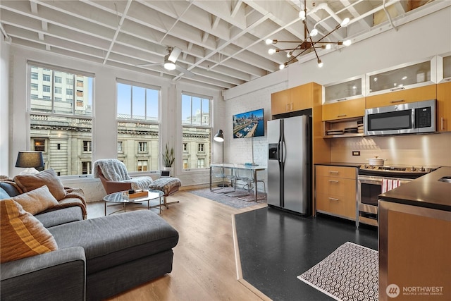 living room featuring a notable chandelier, wood-type flooring, and a high ceiling