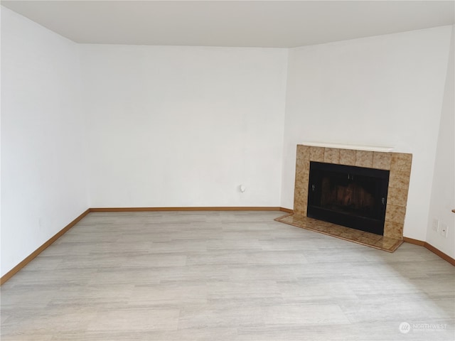 unfurnished living room with a fireplace and light hardwood / wood-style floors