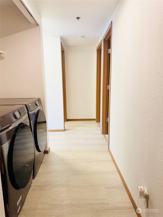 hallway featuring washing machine and clothes dryer and light hardwood / wood-style flooring