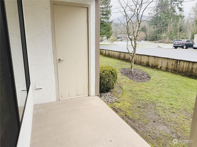 entrance to property featuring a lawn