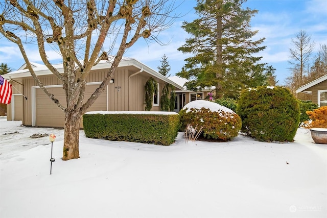 snow covered property with a garage