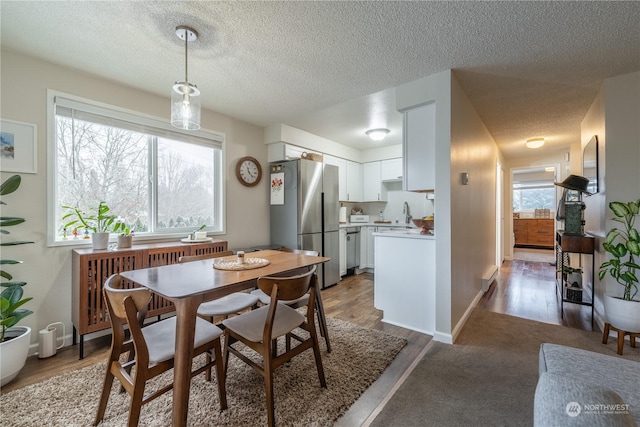 dining room with a textured ceiling and wood finished floors