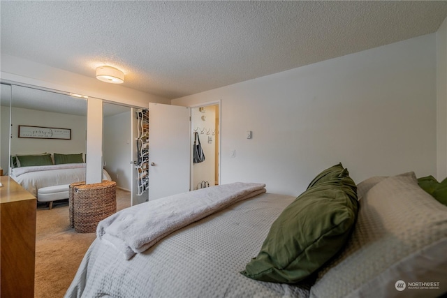 bedroom with a textured ceiling, a closet, and carpet flooring