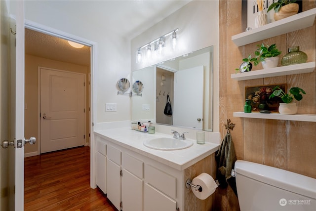 bathroom with vanity, toilet, and wood finished floors