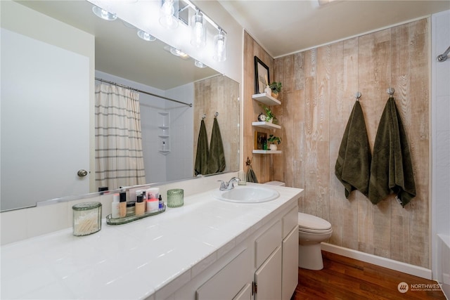 bathroom featuring a shower with shower curtain, toilet, wood finished floors, vanity, and wood walls