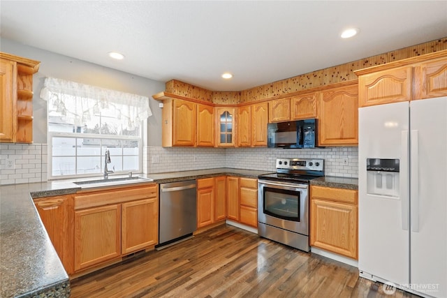 kitchen with dark wood-style floors, stainless steel appliances, recessed lighting, decorative backsplash, and a sink