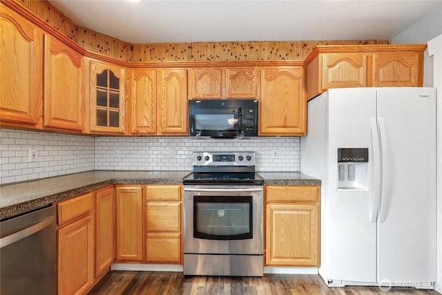 kitchen featuring decorative backsplash, dark wood finished floors, dark countertops, glass insert cabinets, and stainless steel appliances