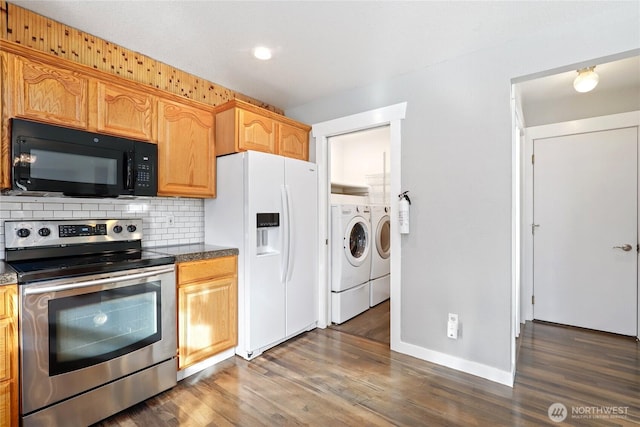 kitchen with electric stove, tasteful backsplash, white fridge with ice dispenser, washer and dryer, and black microwave