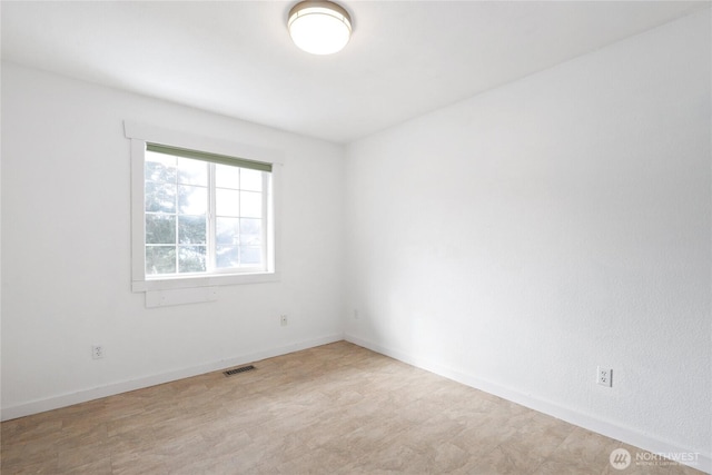 empty room with visible vents and baseboards