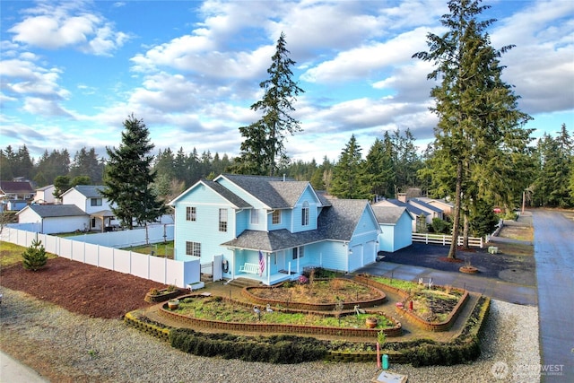 view of front of property featuring an attached garage, fence, and aphalt driveway