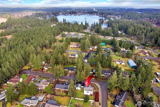 birds eye view of property featuring a forest view and a water view