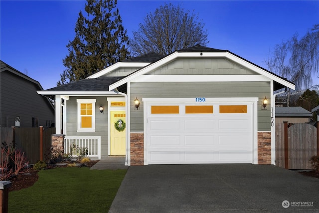 craftsman inspired home featuring a garage and a front lawn