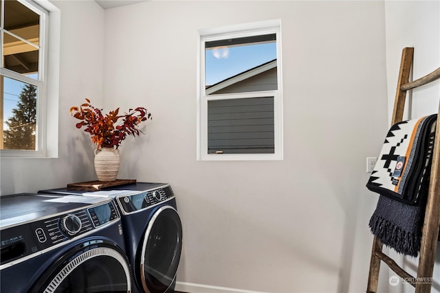 clothes washing area featuring a wealth of natural light and washing machine and clothes dryer