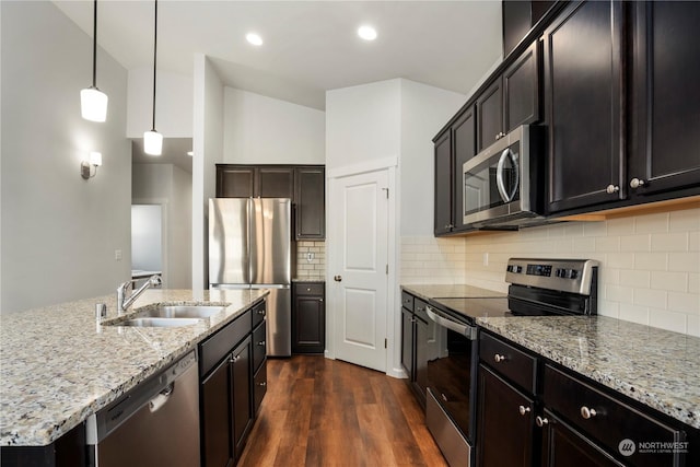 kitchen featuring sink, stainless steel appliances, dark hardwood / wood-style floors, a center island with sink, and decorative light fixtures