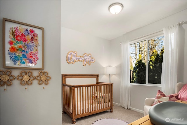 bedroom with light carpet and a nursery area