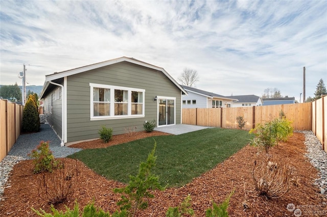 rear view of property with a lawn and a patio