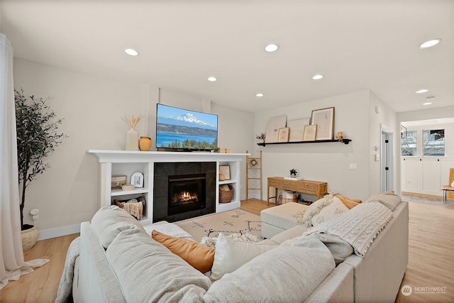 living room with a fireplace, plenty of natural light, and light hardwood / wood-style floors