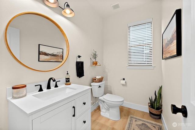 bathroom featuring vanity, hardwood / wood-style floors, and toilet