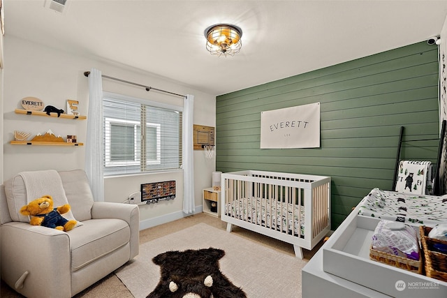 carpeted bedroom with a nursery area and wood walls