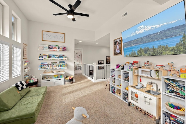 recreation room with sink, ceiling fan, and carpet flooring