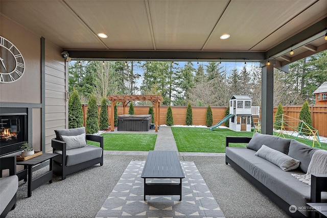 view of patio with a hot tub, outdoor lounge area, and a playground