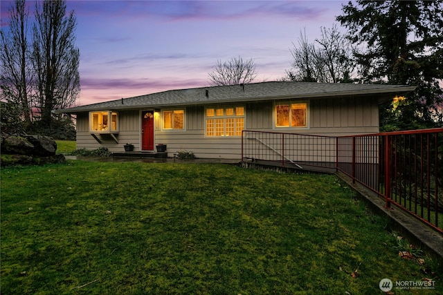 view of front of house featuring fence and a yard