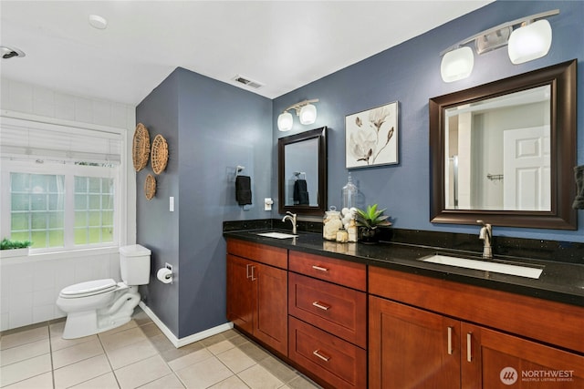 bathroom with toilet, visible vents, a sink, and tile patterned floors