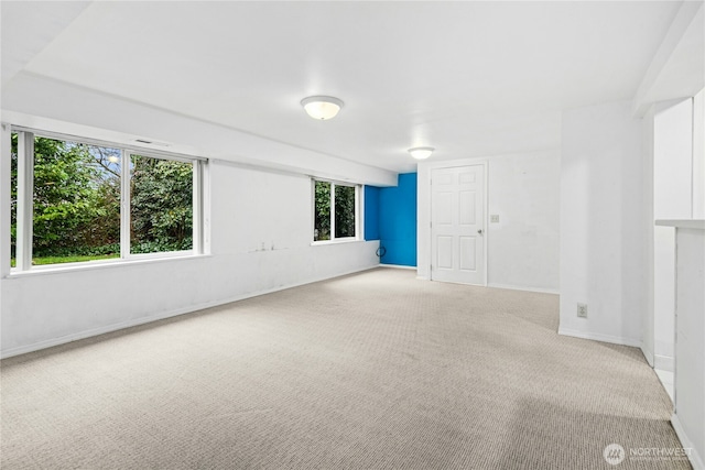 carpeted spare room featuring baseboards