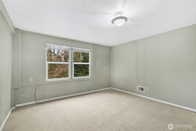 carpeted empty room featuring baseboards and visible vents