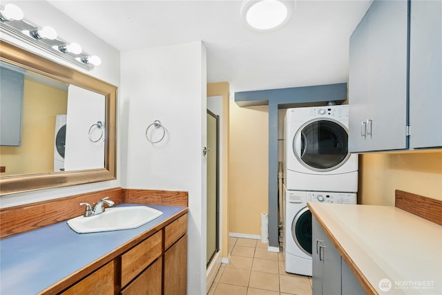 clothes washing area with light tile patterned floors, laundry area, stacked washing maching and dryer, and a sink