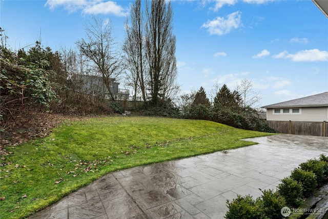 view of yard with driveway, a patio area, and fence