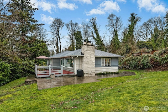 back of house featuring a yard, a chimney, a patio area, cooling unit, and a wooden deck