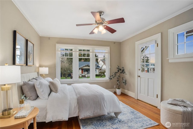 bedroom with ornamental molding, a ceiling fan, baseboards, and wood finished floors