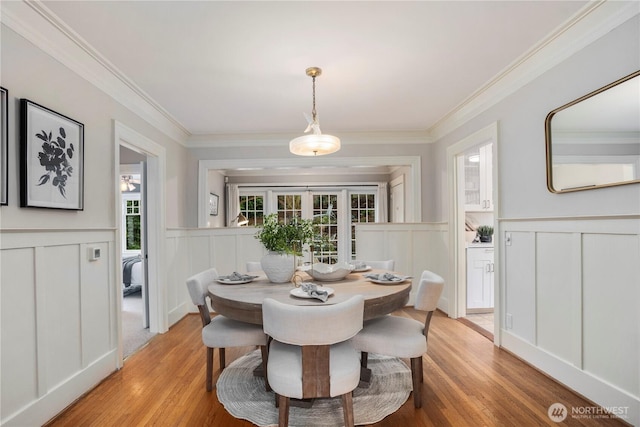 dining room featuring crown molding, plenty of natural light, and light wood finished floors