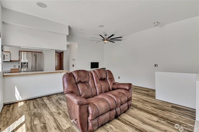 living room featuring ceiling fan and light hardwood / wood-style flooring