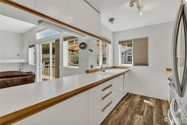 kitchen with dishwasher, sink, stainless steel fridge, white cabinets, and dark hardwood / wood-style flooring