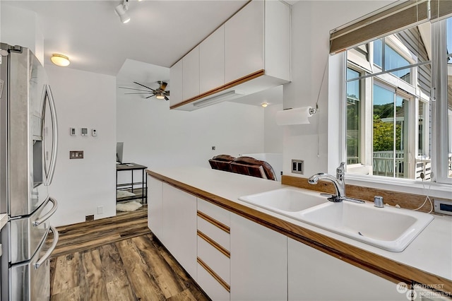 kitchen featuring stainless steel refrigerator with ice dispenser, sink, dark hardwood / wood-style floors, ceiling fan, and white cabinets